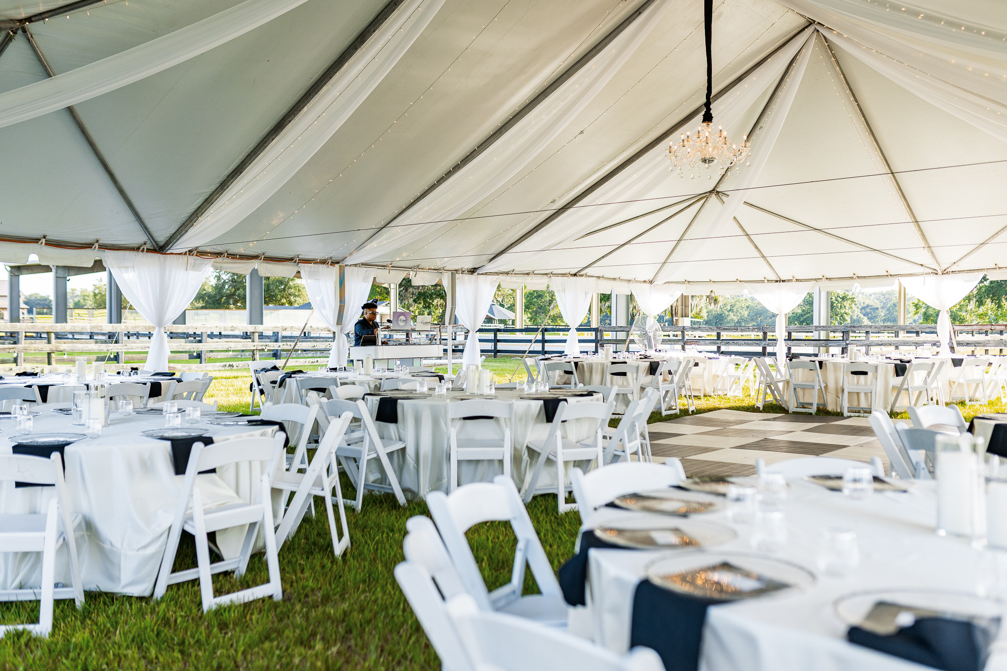 An elegant tented reception with draped fabric and a chandelier